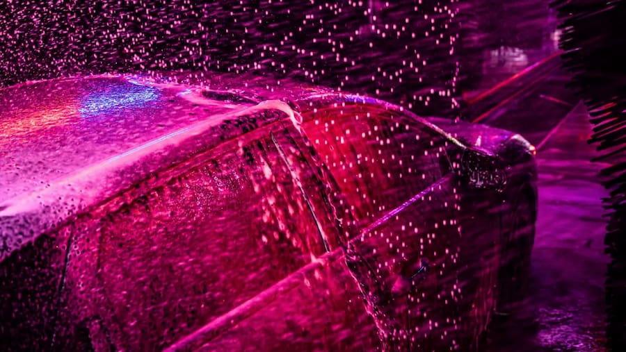 a car in an express car wash tunnel like that at sud stop car wash is covered in soap during the wash process